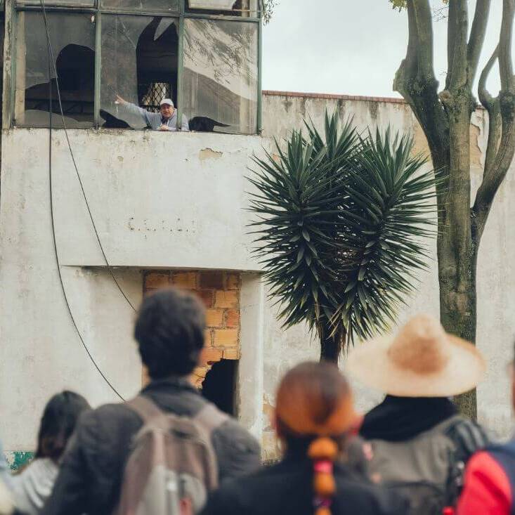 Guia saluda por una ventana en un segundo piso durante el recorrido por el San Juan de Dios