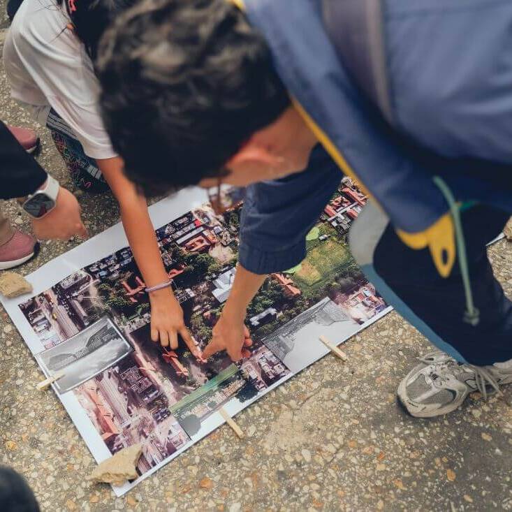Personas señalan un edificio en el mapa del san juan de Dios