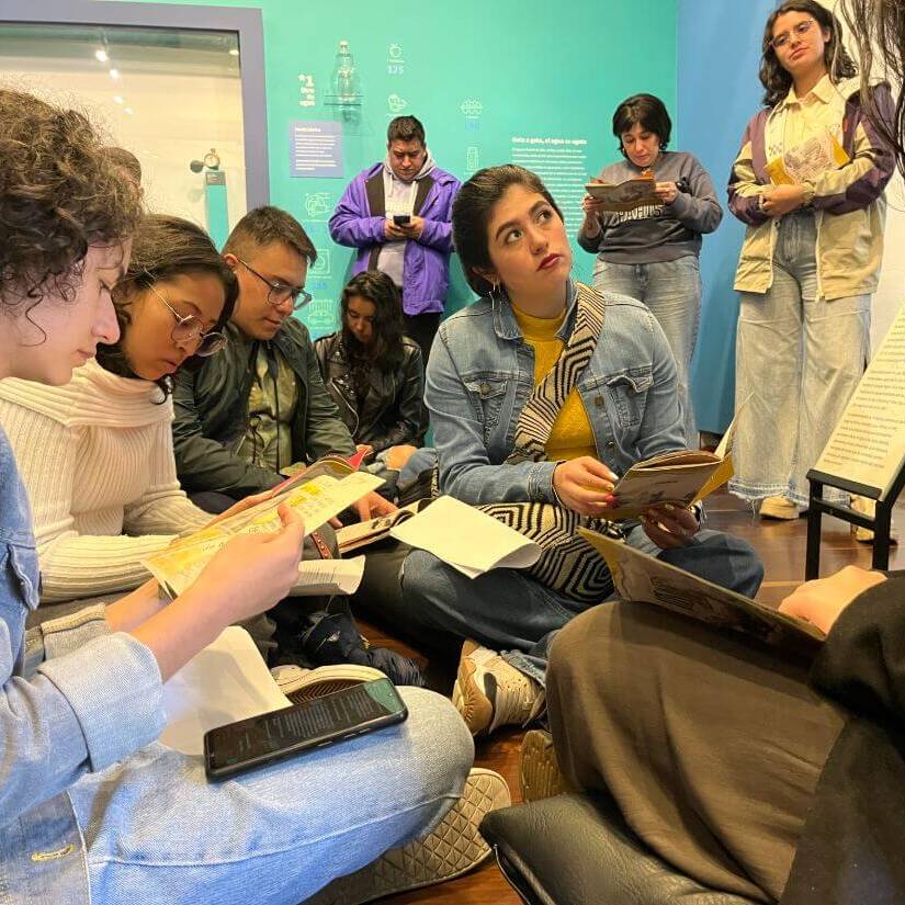Grupo de personas sentadas en el piso leyendo el fanzine