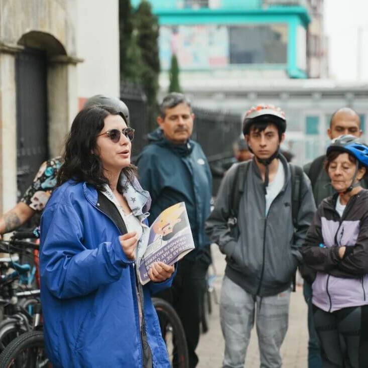 Guia habla al grupo de personas en el bicirecorrido