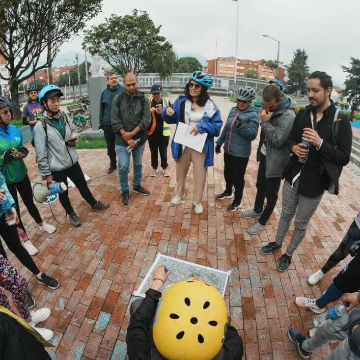 Grupo de personas escucha a la guia del bicirecorrido