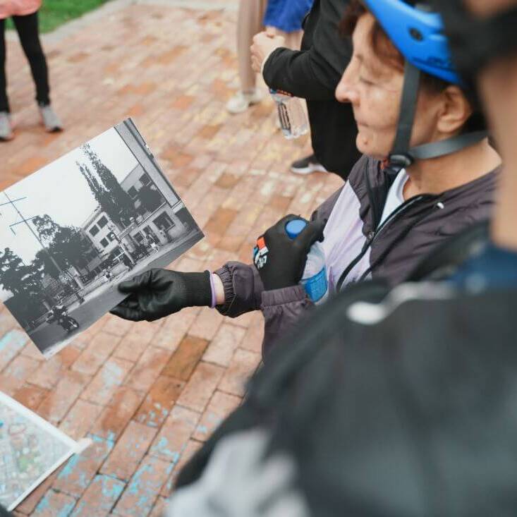 Mujer sostiene una foto antigua durante bicirecorrido