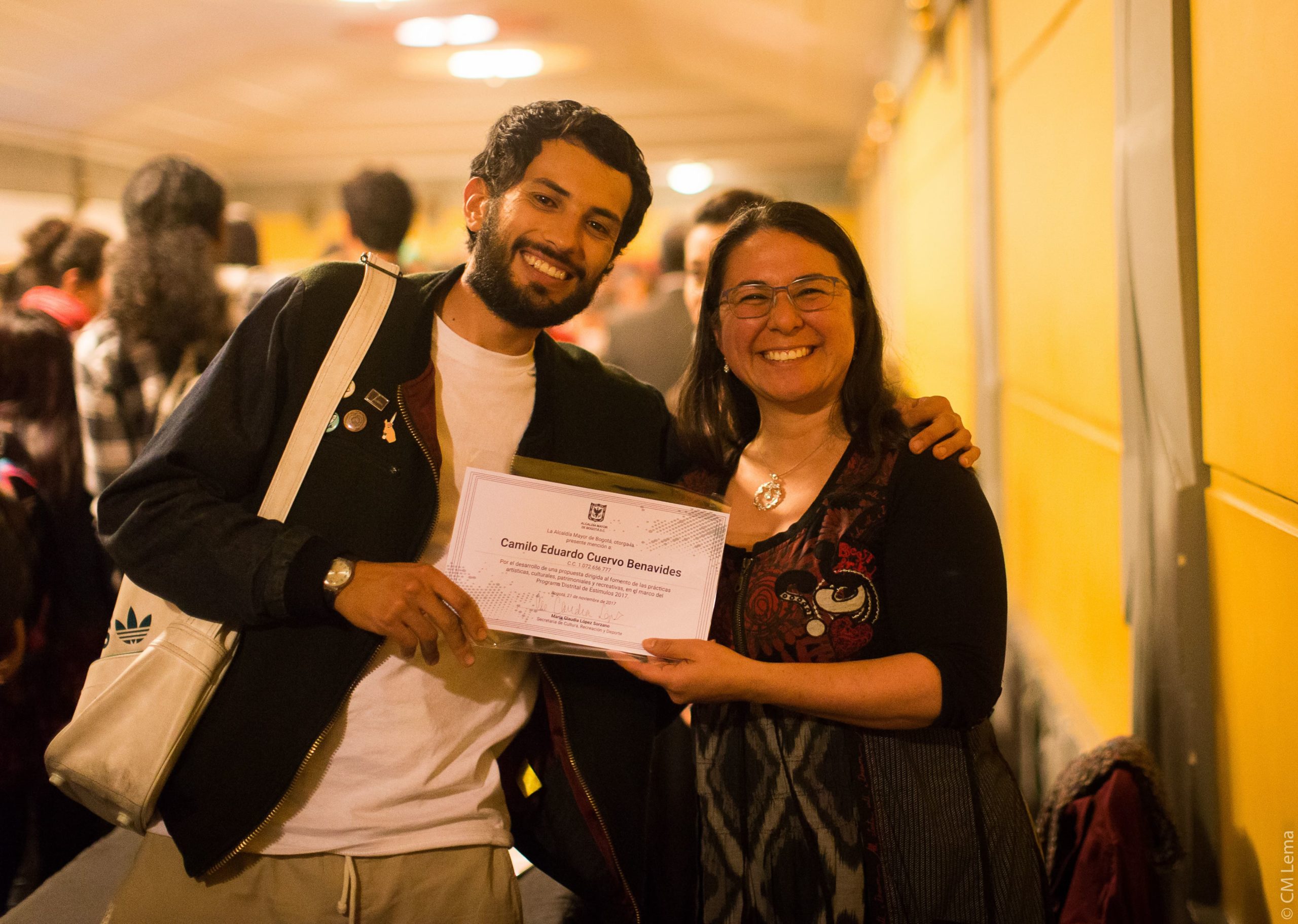 Dos personas sonriendo y sosteniendo un diploma en sus manos