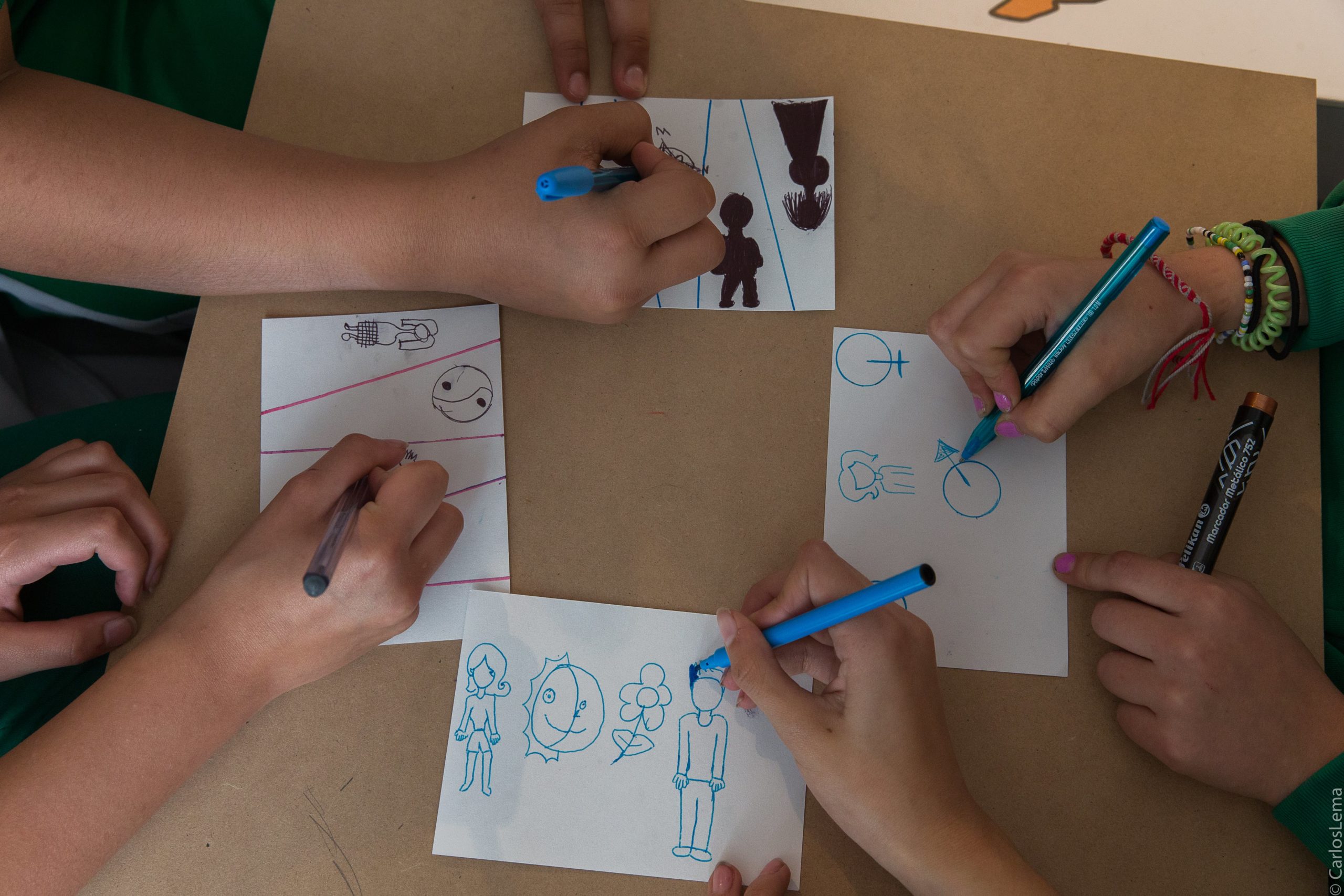 Manos de niños dibujando durante la exposición Hechos y memoria