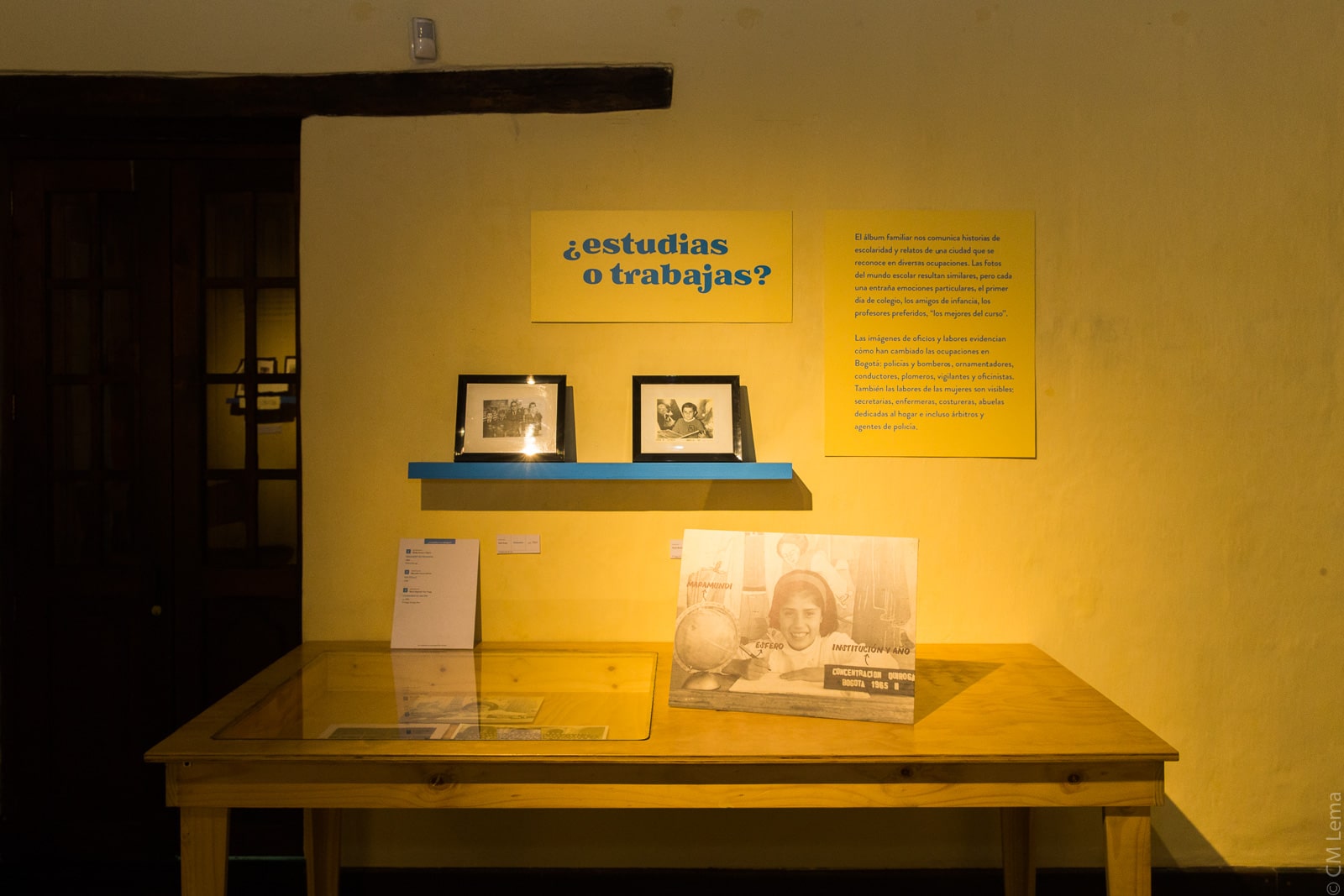 Cuadros fotográficos encima de una mesa en la exposición Temporal Álbum Familiar en la sede Casa Sámano del Museo de Bogotá