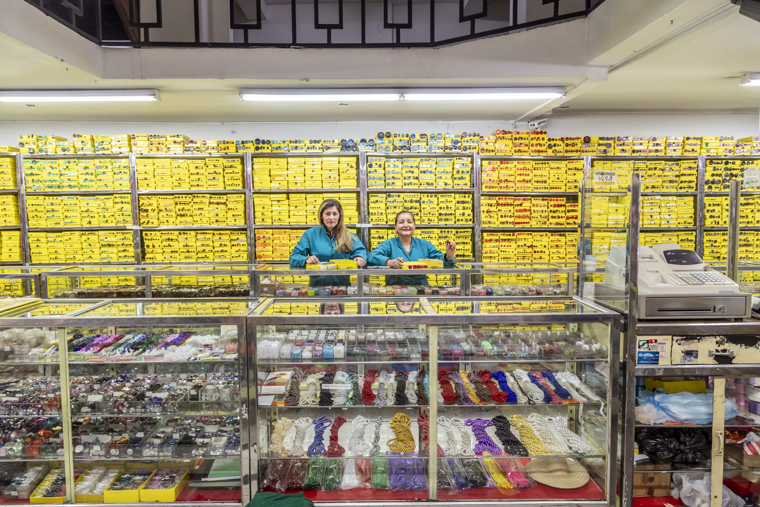 Dos mujeres sobre una vitrina, exhibiendo productos para confección