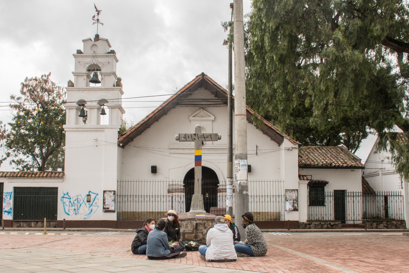 Grupo de personas sentadas frente a iglesia en Bosa