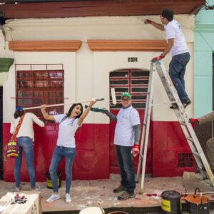 Grupo de personas felices arreglando fachadas