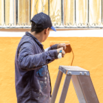 Integrante de la Brigada BIP pintado una fachada