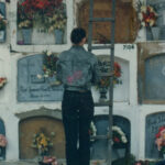 IDPC Campus - Mujer visitando una tumba y llevando flores en el antiguo Cementerio de pobres en los años 90