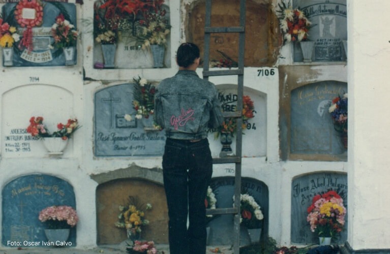 IDPC Campus - Mujer visitando una tumba y llevando flores en el antiguo Cementerio de pobres en los años 90