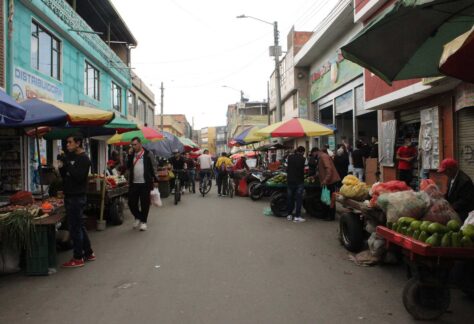 Calle en la localidad de Bosa que muestra comercio tradicional y vendedores ambulantes de aguacate, frutas y verduras.
