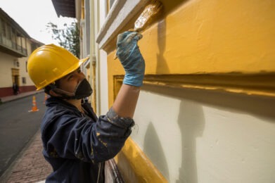 Mujer pintando un pared