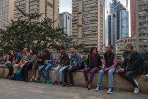 Un grupo de personas sentadas en una pared en una ciudad.