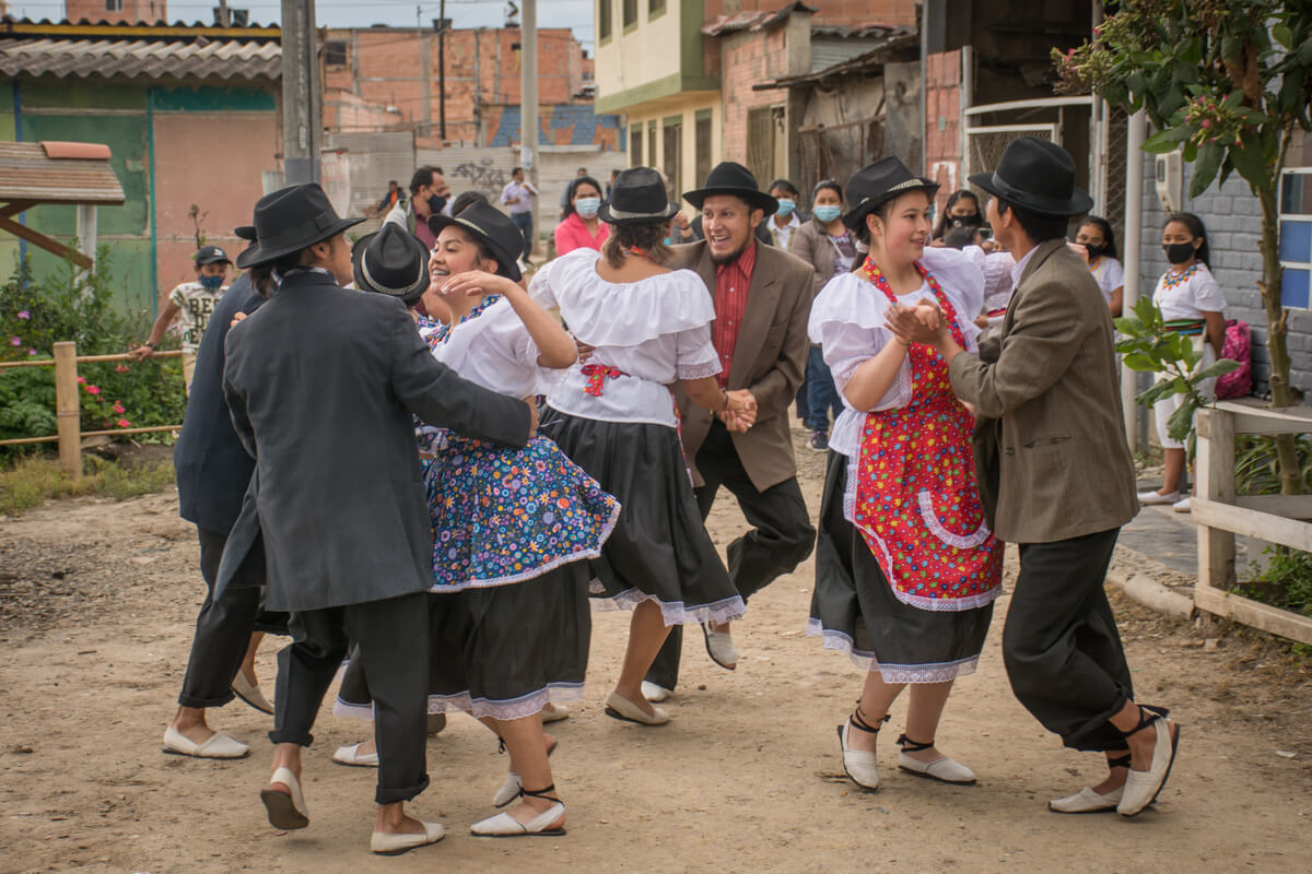 Comparsa hombres y mujeres bailando en las calles junto al Cabildo