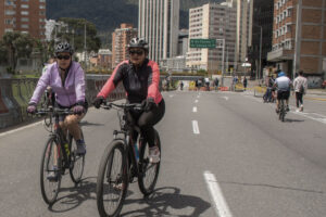 Dos personas montando bicicleta en la ciclovía de Bogotá.