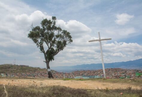 El palo del ahorcado con la cruz al lado y ciudad bolivar al fondo