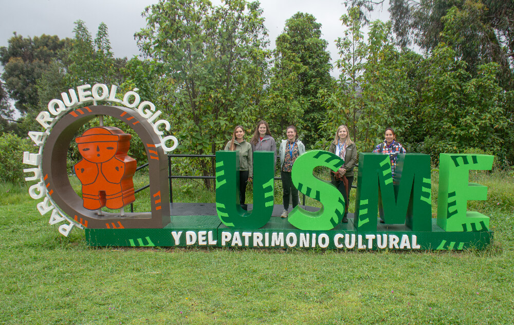Delegados de washington posan frente al letrero del Parque Arqueológico y del patrimonio cultural de usme
