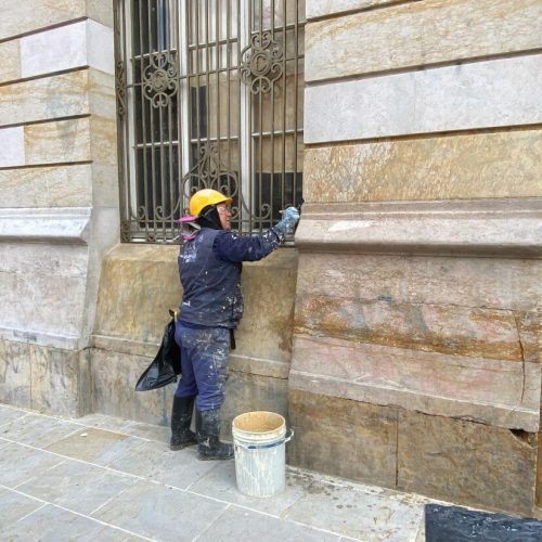 Integrante de la brigada de intervención al patrimonio trabajando en la restauración de la fachada del palacio San Francisco