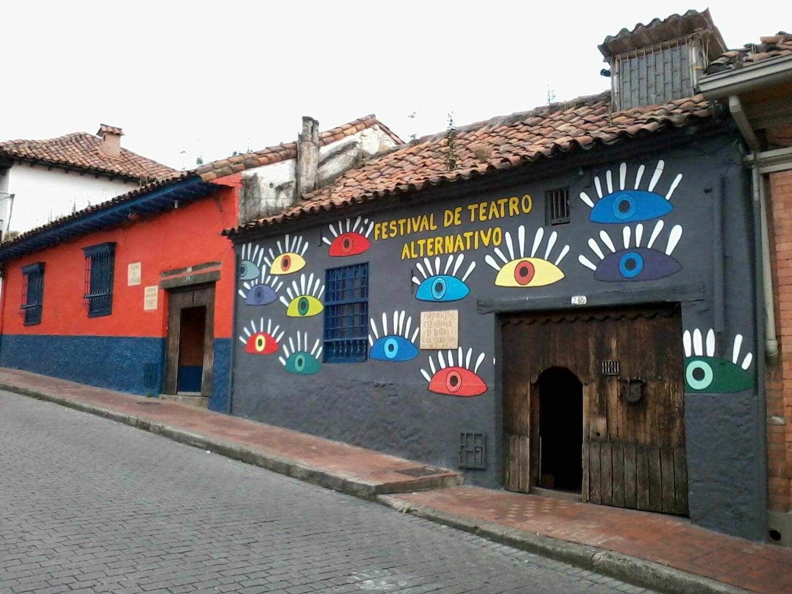 Fachada del festival de teatro alternativo, una pared negra con ojos de colores pintados