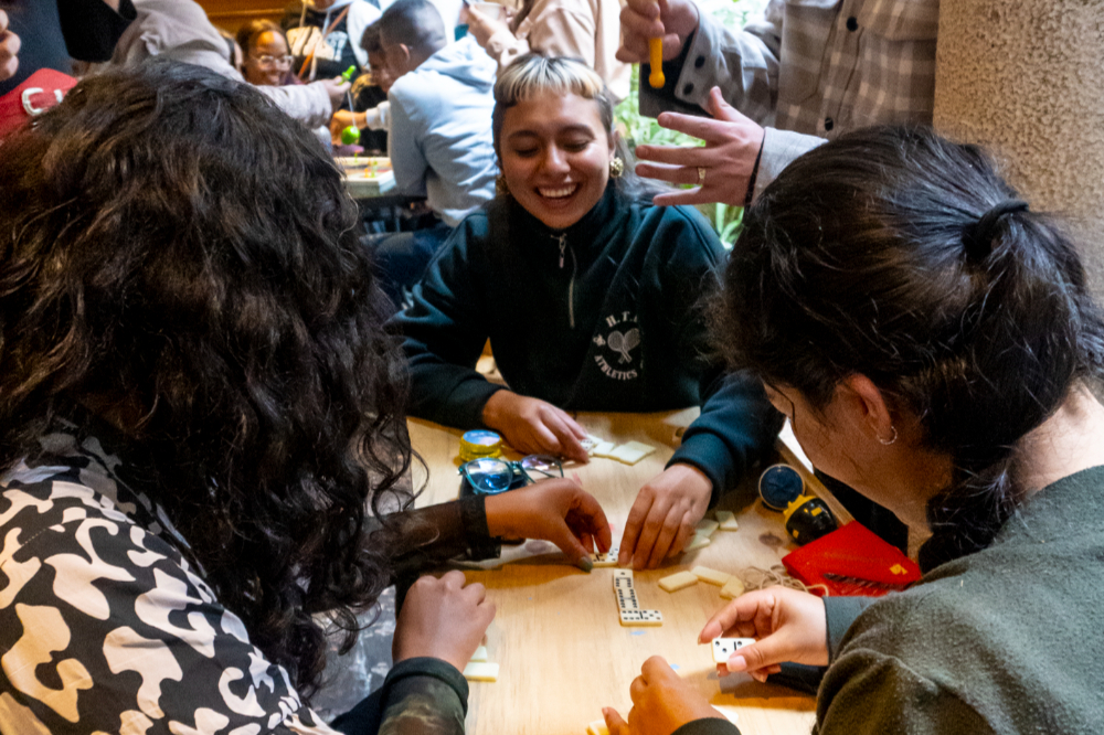 Grupo de personas en el museo de Bogotá sonrie jugando juegos de mesa