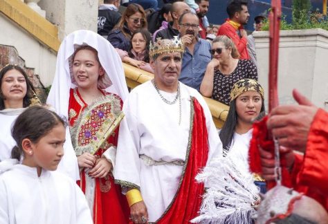 Representantes de los Reyes Magos y otros personajes saludan al público durante el desfile.