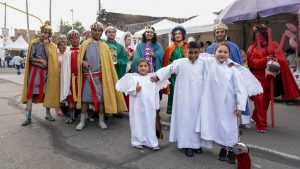 Grupo de actores y vecinos caracterizados como los Reyes Magos y figuras bíblicas posan en una calle del barrio Egipto