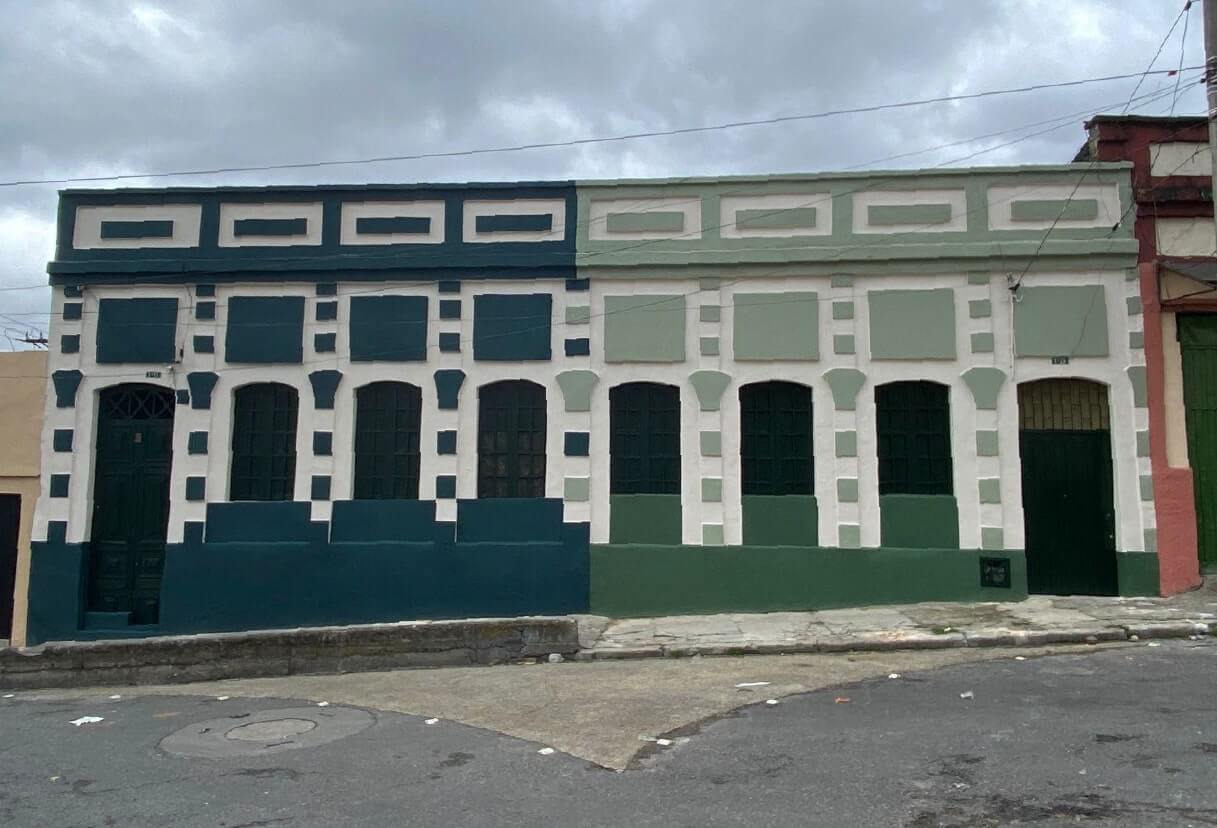 Fachada del centro historico de color verde y blanco luego de ser intervenida