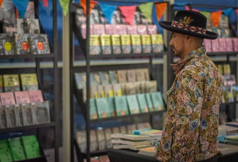 Visitantes recorriendo una mesa con libros y publicaciones del IDPC en exhibición.