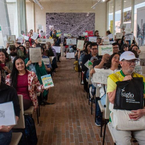 Asistentes mostrando sus dibujos de Bogotá en distintos formatos.