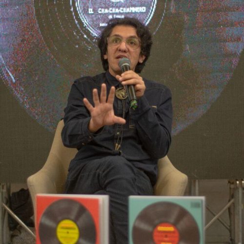 Autor del libro Bogotá Encubierta presentando sobre un escenario con ejemplares frente a él.