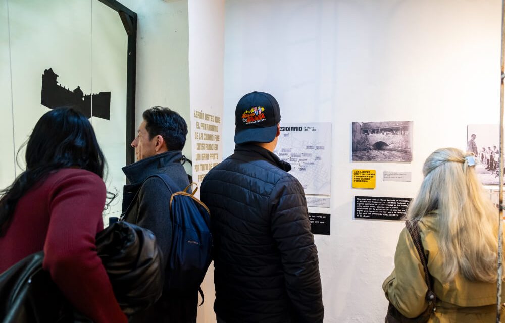Grupo de visitantes recorre paneles con mapas, cifras y gráficos sobre la situación carcelaria en Colombia.
