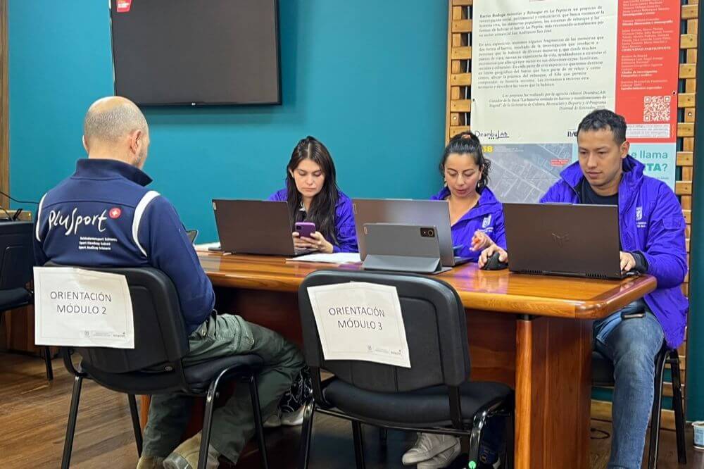Funcionarios trabajando en computadores durante una jornada de atención a usuarios en una sala de servicio.
