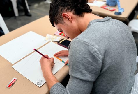 Un joven dibuja una escena urbana con lápiz