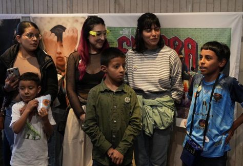 Un grupo de niñas y niños reunidos en el Centro de Memoria, Paz y Reconciliación, observando juntos con alegría y atención el montaje.