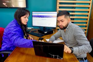 Funcionaria del IDPC y ciudadano analizando información técnica en una computadora portatil durante la atención presencial.