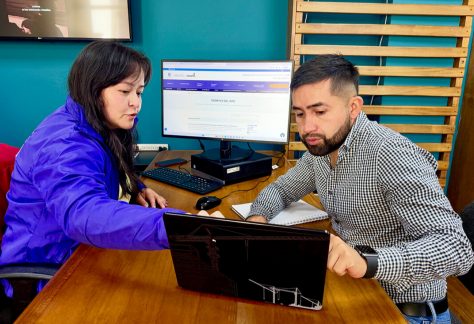Funcionaria del IDPC y ciudadano analizando información técnica en una computadora portatil durante la atención presencial.