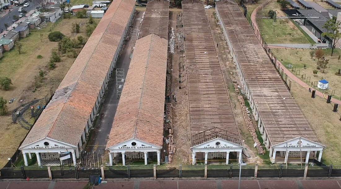 Vista panorámica y aérea de la estructura de Los Columbarios en Bogotá, mostrando los techos rectangulares de las galerías cementeriales y los frontones con la inscripción La vida es sagrada