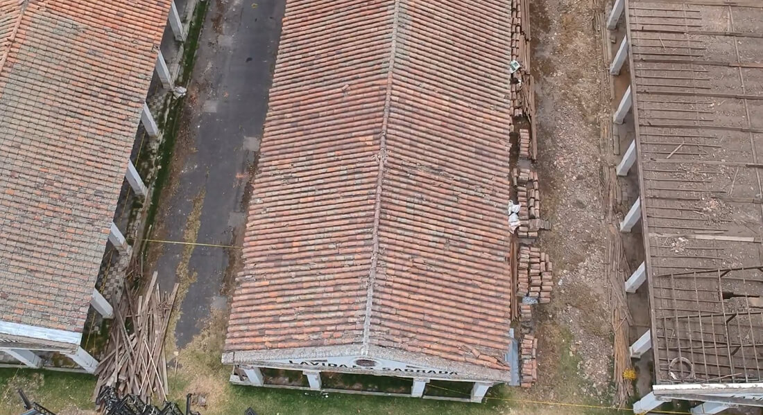 Vista aérea en picado del techo en teja de Los Columbarios en proceso de conservación, con andamios y estructura de obra alrededor.