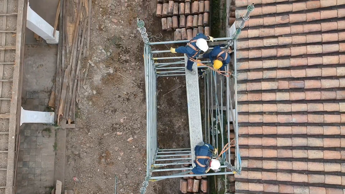 Técnicos en arnés realizando trabajos de restauración sobre un andamio suspendido en Los Columbarios.