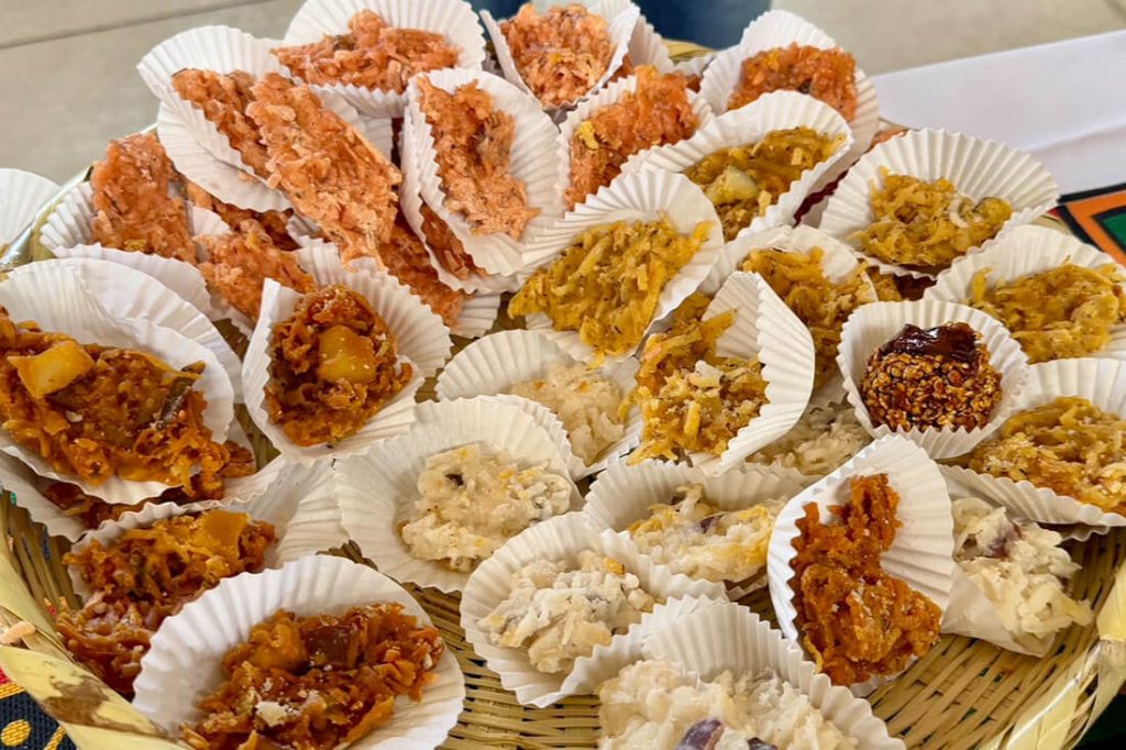 Mesa con una variada exhibición de dulces y cocadas artesanales tradicionales servidas en recipientes individuales.