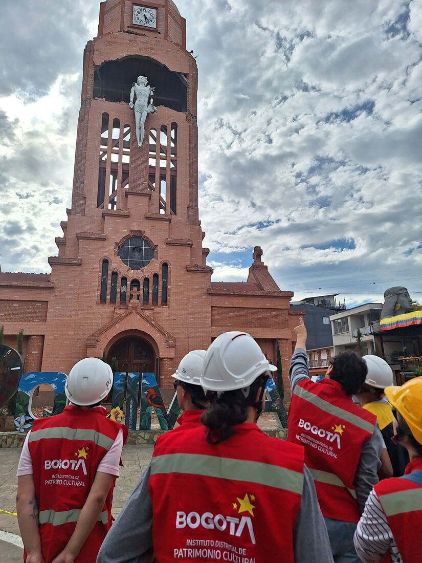Fachada principal de la Basílica Menor de Jesús, María y José en Quimbaya, vista desde la base mientras profesionales del IDPC con chalecos rojos realizan una inspección técnica.