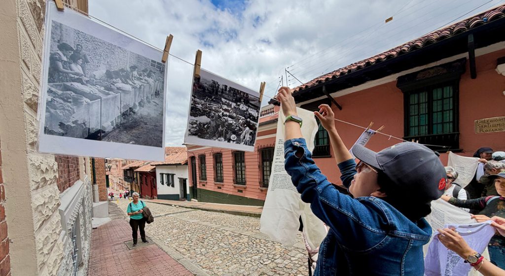 Asistentes al recorrido colgando ampliaciones de fotografías históricas del río Chiguachí en la vía pública.