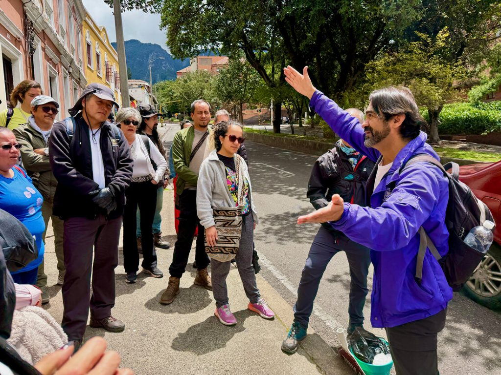 Un guía del IDPC señalando al frente mientras sostiene un megáfono durante el recorrido patrimonial por el río Chiguachí.