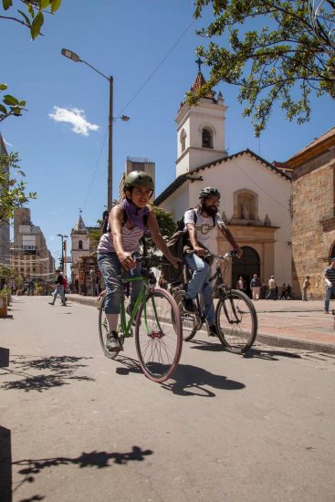 dos jóvenes montando bicicleta en el Centro Histórico de Bogotá
