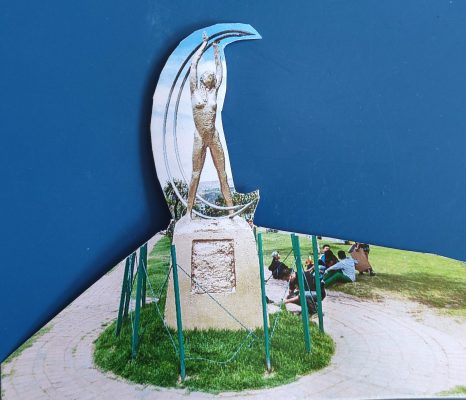 Primer plano de un recorte de una fotografía de un monumento de una mujer desnuda y una medialuna.